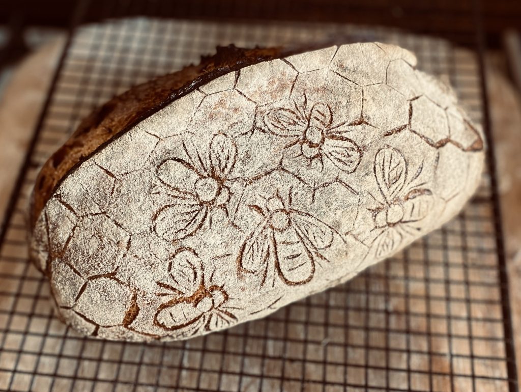 sourdough bread with bee scoring pattern